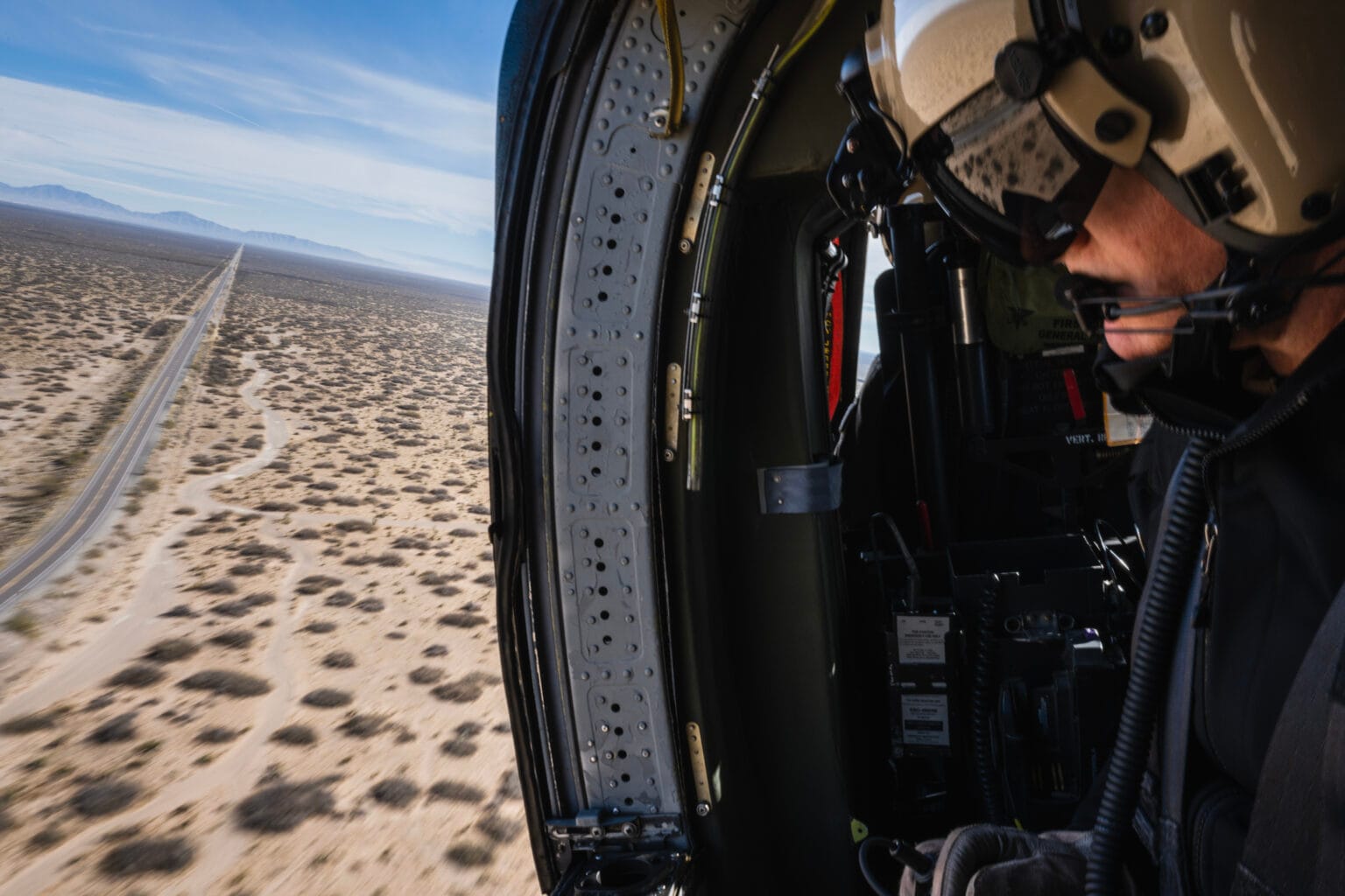 John Stonehouse, director of Air and Marine Operations for the El Paso sector, looks out from a helicopter while patrolling Highway 9, a remote corridor used by smugglers in southern New Mexico.