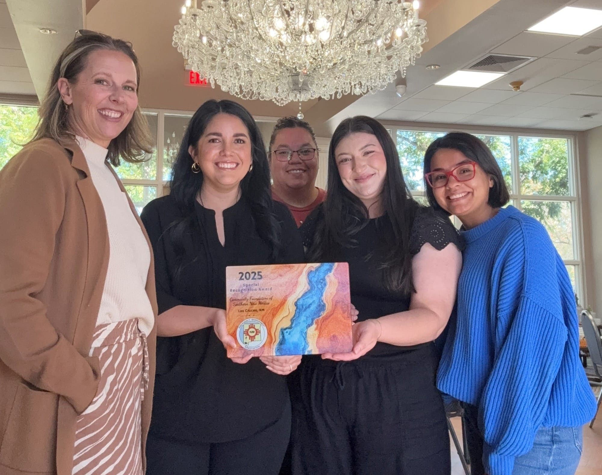 Five members of the Community Foundation of Southern New Mexico smile together indoors while holding the 2025 Special Recognition Award.