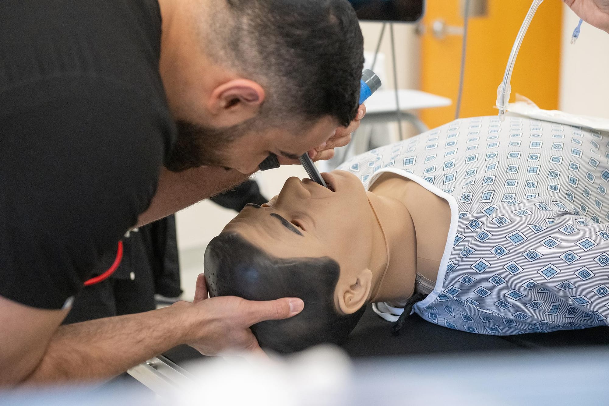 A nursing student practices inserting a breathing tube on a high-fidelity medical training mannequin inside NMSU’s new simulated operating room.