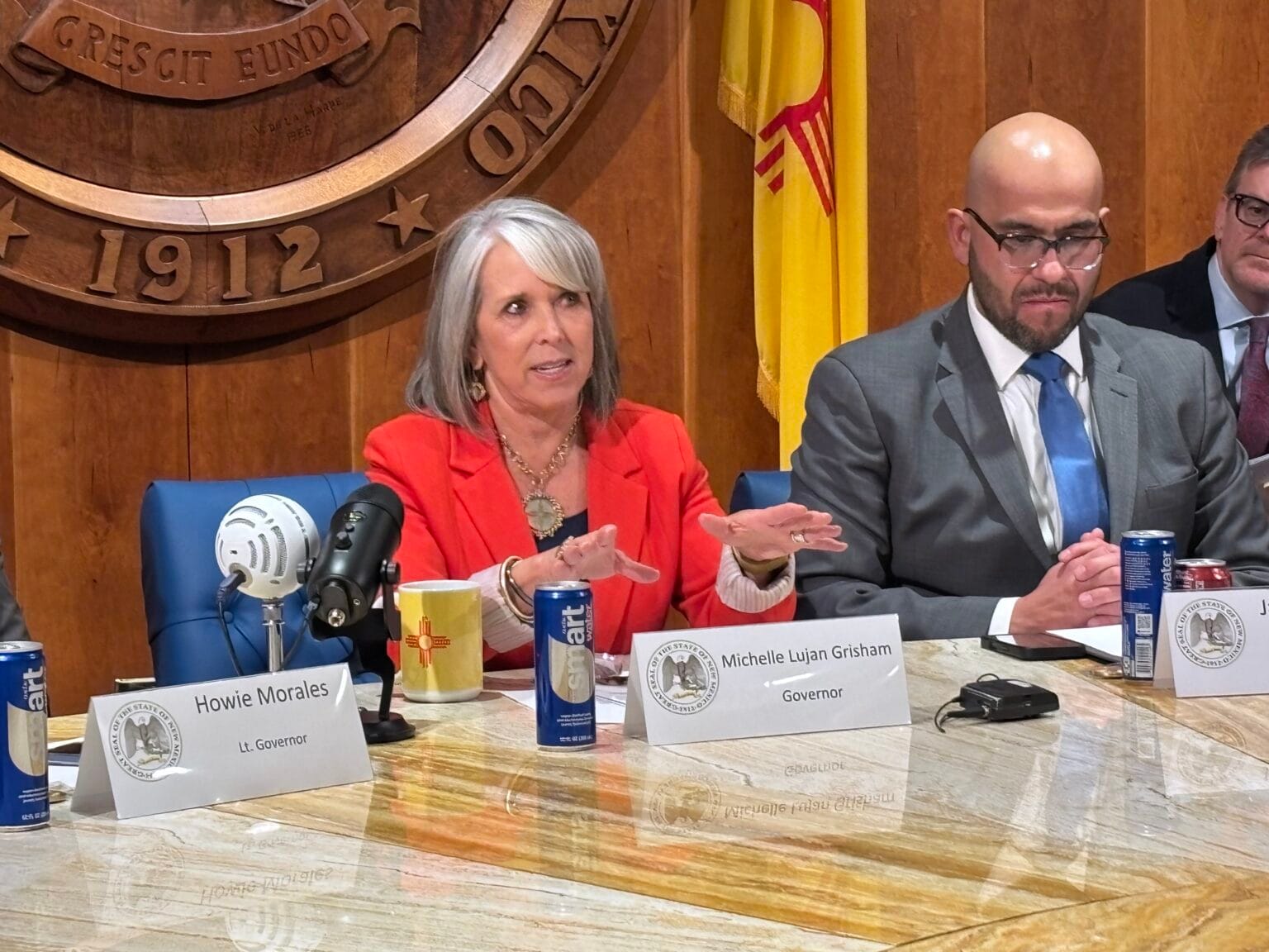 New Mexico Gov. Michelle Lujan Grisham speaks at a Roundhouse news conference after the legislative session, seated beside House Speaker Javier Martínez.