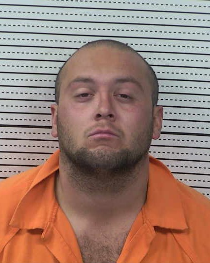 Booking photo of Gino Pina, 26, wearing an orange detention uniform against a height chart background.