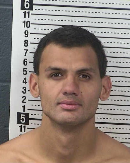Booking photo of Fabian Marcos Bojorquez against a height chart background