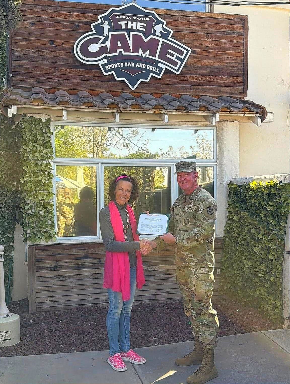 Marci Dickerson receives the New Mexico Medal of Merit from Brig. Gen. Nathaniel Carper outside The Game
