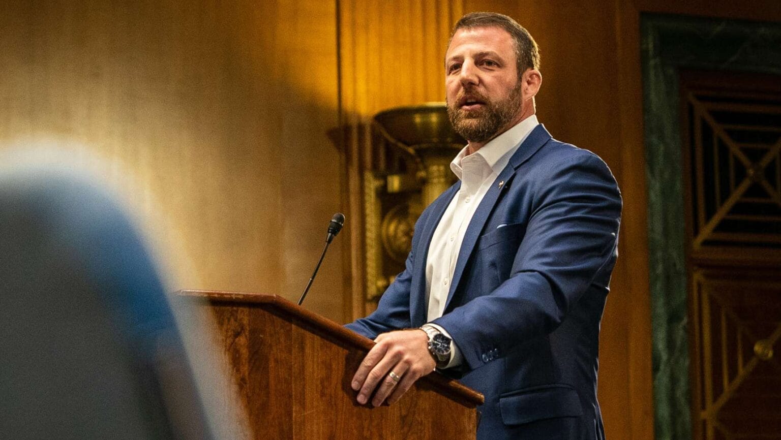 U.S. Sen. Markwayne Mullin speaks at a podium during an official event in Washington.