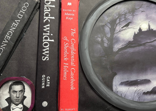 A Halloween-themed display at Branigan Library includes the books Cold Vengeance, Black Widows and The Confidential Casebook of Sherlock Holmes, with Dracula’s image and a moonlit castle.