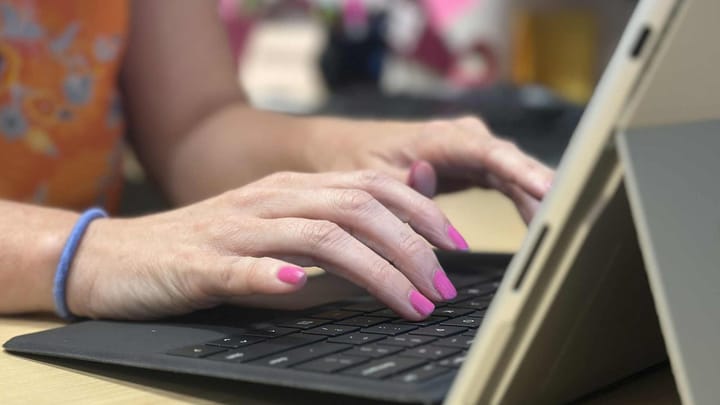 Close-up of a person typing on a tablet keyboard, illustrating safe technology and cybersecurity awareness.
