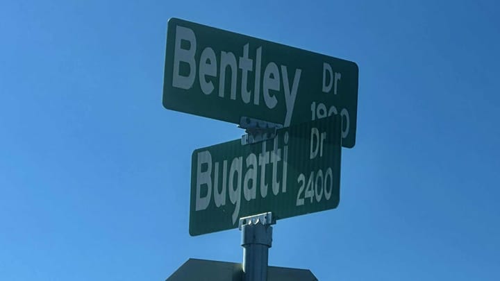 Street signs for Bentley Drive and Bugatti Drive are shown against a clear blue sky at the intersection where Las Cruces police responded to a fatal shooting at a house party.
