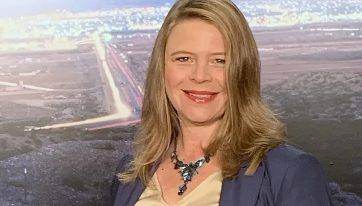 KC Counts smiles in a professional headshot. She has shoulder-length hair and is wearing a patterned blouse.