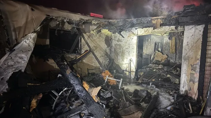 Charred remains of a Las Cruces home after an early morning fire on Sacramento Street, with heavy damage visible inside the burned structure