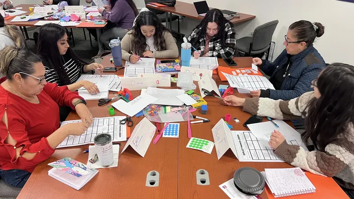 Educators sit around tables during a professional development workshop hosted by NMSU and Las Cruces Public Schools focused on reading science and literacy instruction.