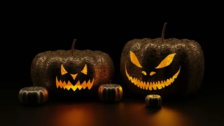 Two glowing jack-o’-lanterns with menacing carved faces sit side by side, flanked by two smaller pumpkins, against a dark background.
