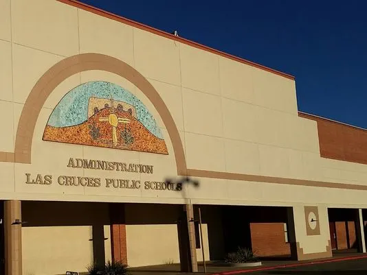 Exterior of the Las Cruces Public Schools administration building, with the district name and mosaic emblem displayed above the entrance.