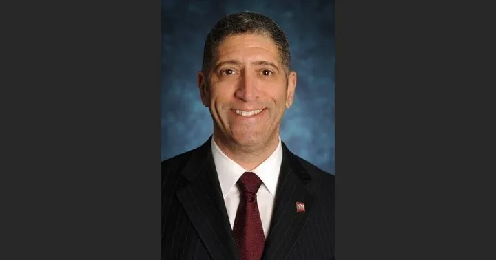 Portrait of former New Mexico State athletics director Mario Moccia wearing a suit and tie.